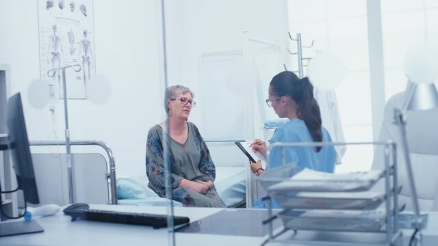 Young female nurse checking on elderly senior patient in medical modern clinic. Healthcare in modern hospital or private clinic, disease prevention and consultation in medic office treatment