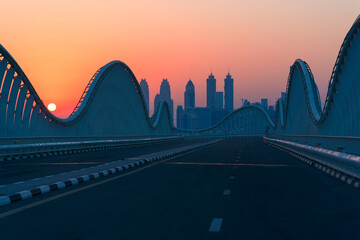 sunset over modern abstract bridge with modern skyscrapers on the background. 