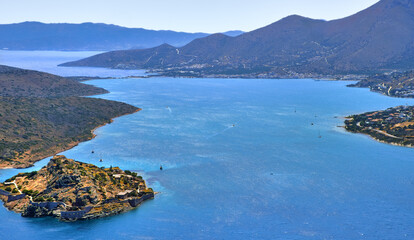 View of harbor between Spinalonga island and peninsula, known as Kalydon, and Plaka village from above, Crete, Greece.