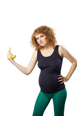 Cute caucasian adult pregnat woman in sportswear with banana