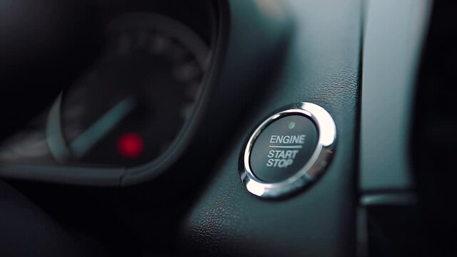 activates the car engine by pressing the button with woman finger. car start stop. pushing the start button