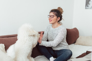 Young woman enjoying with her dogs. Young woman siting on sofa and enjoying with her pets.