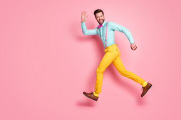 Fototapeta na wymiar Full length body size profile side view of his he nice well-dressed attractive classy cheerful cheery glad brunet guy gentleman jumping running waving hi isolated on pink pastel color background