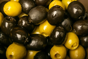 Green olives and black olives the texture of the surface. Close up.