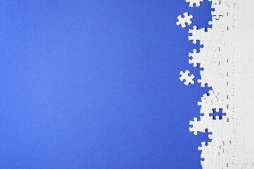 Blank white puzzle pieces on blue background, flat lay. Space for text