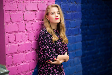 beautiful young woman near a bright colored wall