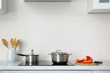 Kitchen counter with utensils and cookware on stove