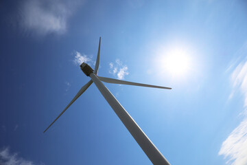 Wind turbine against beautiful blue sky, low angle view. Alternative energy source