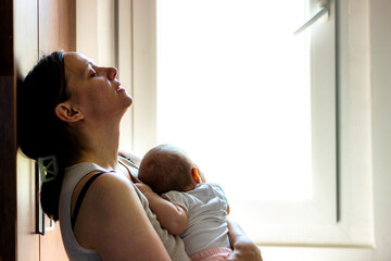 Mother embracing her baby girl while sleeping,lifestyle concept.Tired concerned mother rocking...