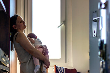 Mother embracing her baby girl while sleeping,lifestyle concept.Tired concerned mother rocking...