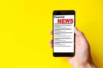 A male hand holds a smartphone, points a finger, types. Communication on a smartphone, correspondence. Place for text. Smartphone in hand on a yellow  background.