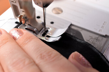 Making a medical black mask with your own hands at home. DIY protective mask. Black mask on a white background. Cotton mask
