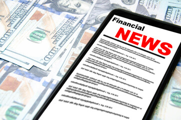 The smartphone on the screen the inscription financial news lies on dollars. 100 dollars banknotes and smartphone with financial news.