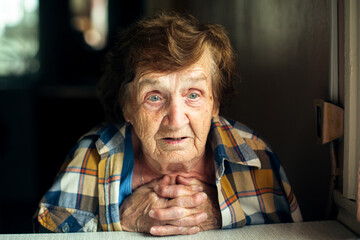 Close-up of portrait of an emotional old woman. Caring for the elderly.