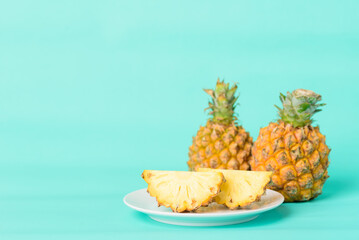 Fototapeta na wymiar Fresh pineapple fruit on plate with pastel green background, Tropical fruit