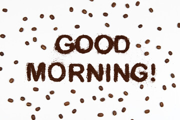 Good morning made from ground coffee with some roasted grains on white isolated background. 
