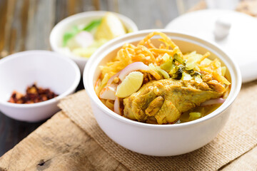 Northern Thai food (Khao Soi), Spicy curry noodles soup with chicken in a bowl 