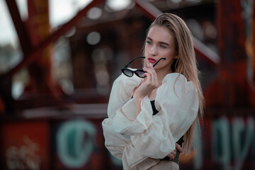 A modern stylish woman or girl posing on abandoned building.