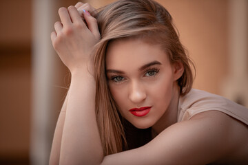 Fototapeta premium close-up portrait of a young girl hipster beautiful blonde with red lips posing against the backdrop of the city