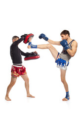 Two caucasian men exercising thai boxing in  studio on white background