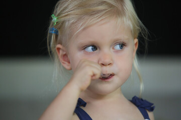 Child eating a piece of chocolate cake in living room