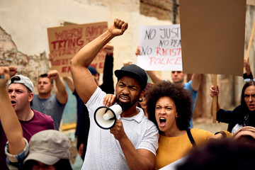 African American couple among crowd of people on public demonstrations. - obrazy, fototapety, plakaty