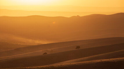 Sunrise or sunset. Inspirational sky background. Calming and relaxing colors and soft light on hills. Sunset landscape in National Park Uzbekistan.