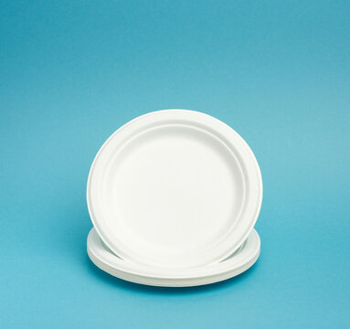 Stack Of White Paper Disposable Plates On A Blue Background