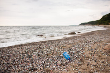 Plastic bottle is on the beach leave by tourist. Ecology, garbage, environmental pollution