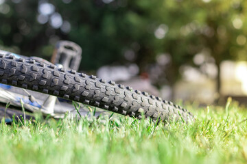 Closeup of a rubber bicycle wheel leaning on the ground, rubber cracked on the tyre over time. Concepts of accidents and bike safety