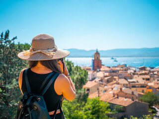 femme en vacance regardant le clocher de Saint-tropez  avec son appareil photo