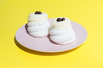 white cake on a pink plate on a yellow background