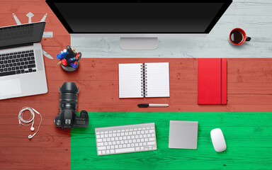 Oman flag background with headphone,camera, notebook and mouse on national office desk table.Top view with copy space.Flat Lay.