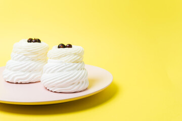 white cakes on a pink plate on a yellow background