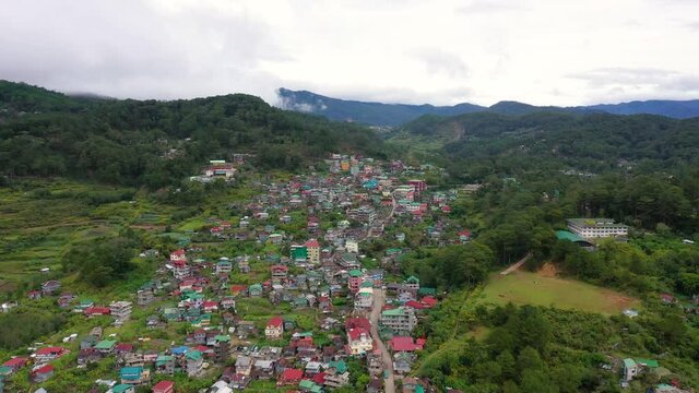 The town is surrounded by mountains, a top view. Sagada city on Luzon island, Philippines. Houses and streets of a mountain town. Village in Cordillera mountains.