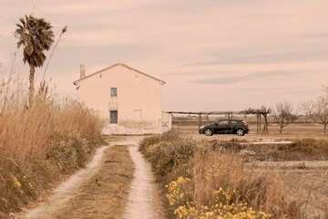 White countryside house with a car parked near it