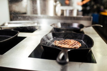 Cooking beef steak on a black grill pan 