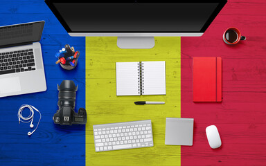 Romania flag background with headphone,camera, notebook and mouse on national office desk table.Top view with copy space.Flat Lay.