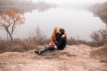 A couple in love against the background of the river, fog over the water, a guy with a girl...