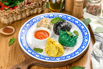 Manti of different colors on a plate with a pattern. Close-up shot in the decor