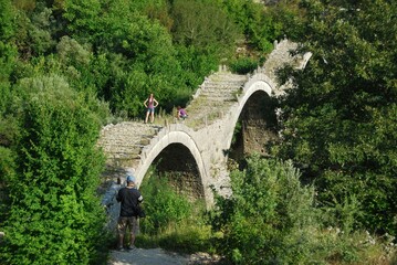 Fototapeta na wymiar The traditional three-arched stone-made bridge Kalogeriko at Kipoi village, one of the 45 villages known as Zagoria or Zagorochoria in Epirus region of southwestern Greece, August 9 2010.