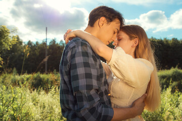 Blonde girl and dark hair guy happily together in nature, love story