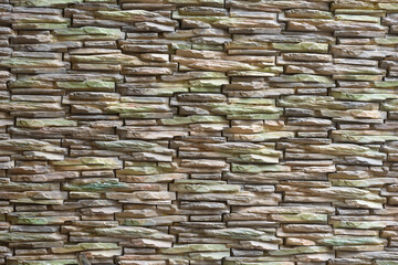 Portrait of stone wall made of thin bricks stacked together