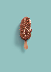 Crashed vanilla and chocolate ice cream popsicle on a blue background