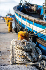 Variety of ropes tied around yellow pole to secure boat