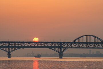 Obraz na płótnie Canvas railway and highway combined bridge in sunrise
