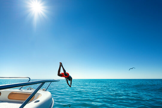 Boy Jumping From Boat In The Water