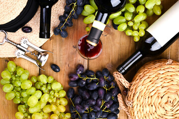 Traditional Italian harvest festival, symbol of summer vacation. On a wooden background Grapes, wine is pouring from a bottle into a glass. Stop motion.