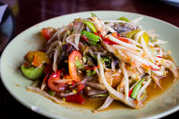 Fresh made hot papaya salad Som Tam with bean, carrot and peanuts. Traditional thai cuisine.