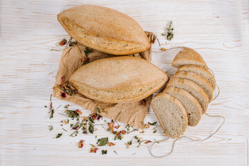 Fresh crunchy bread loafs and pieces on the wooden background